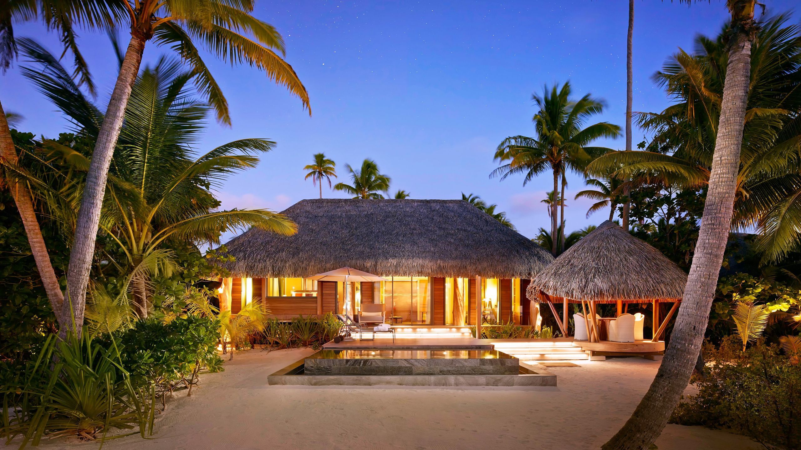 Thatched villa lit at dusk